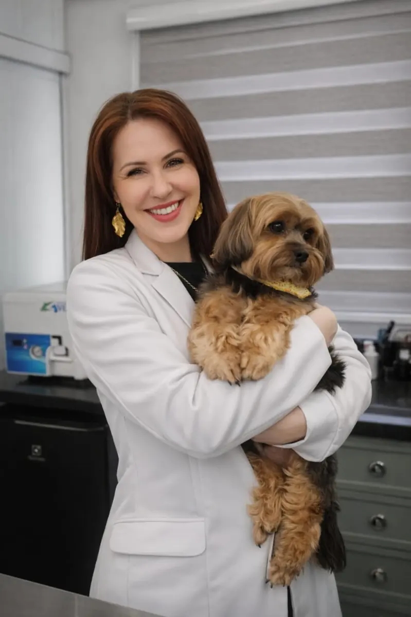 Dra. Clarice Cacciari, médica veterinária dermatologista, com um cão no colo
