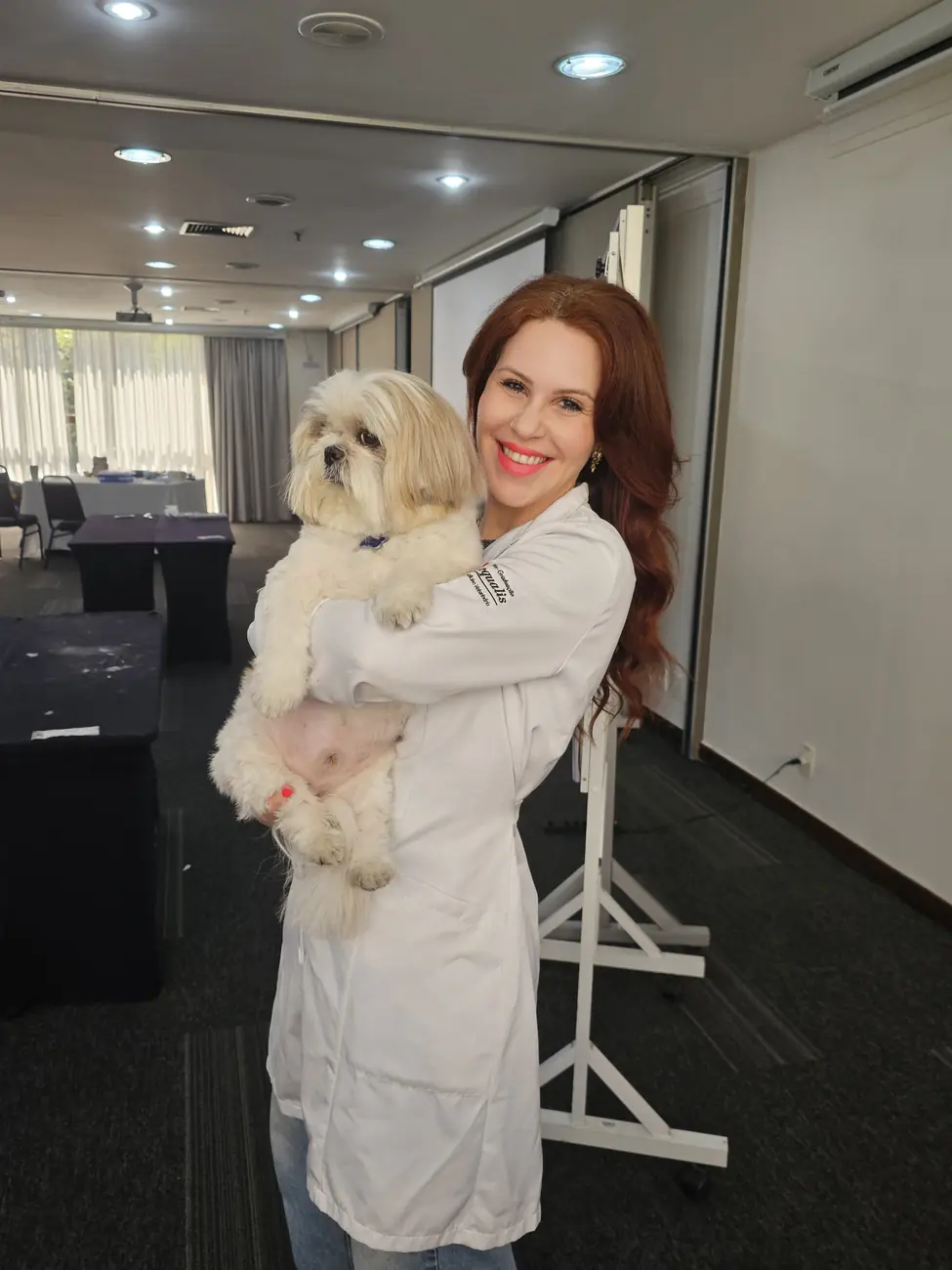 Dra. Clarice Cacciari segurando um cachorro no consultório