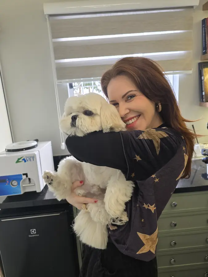 Dra. Clarice segurando um cão de pelo claro